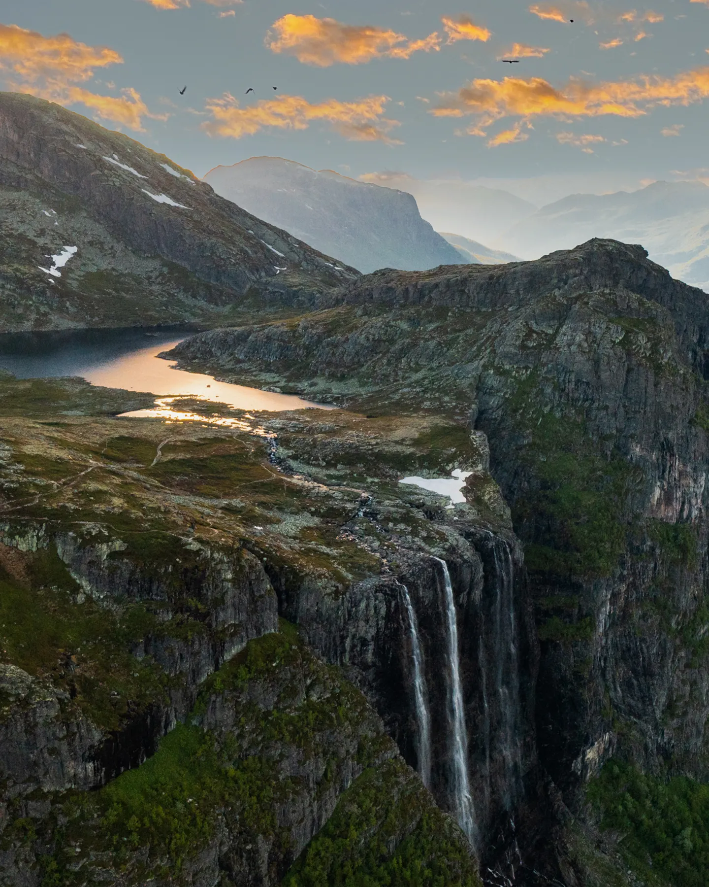 Fjellandskap med foss og innsjø i Hemsedal ved solnedgang om sommeren
