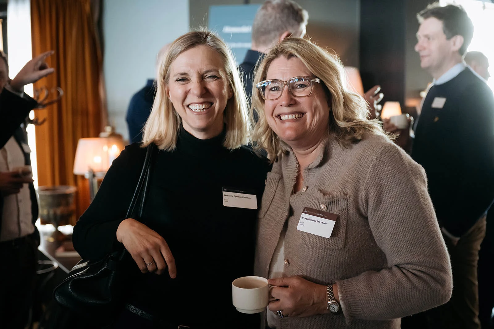 Verdifulle møter og nye relasjoner To deltakere smiler under nettverking på Oslo Business Forum Executive Experience