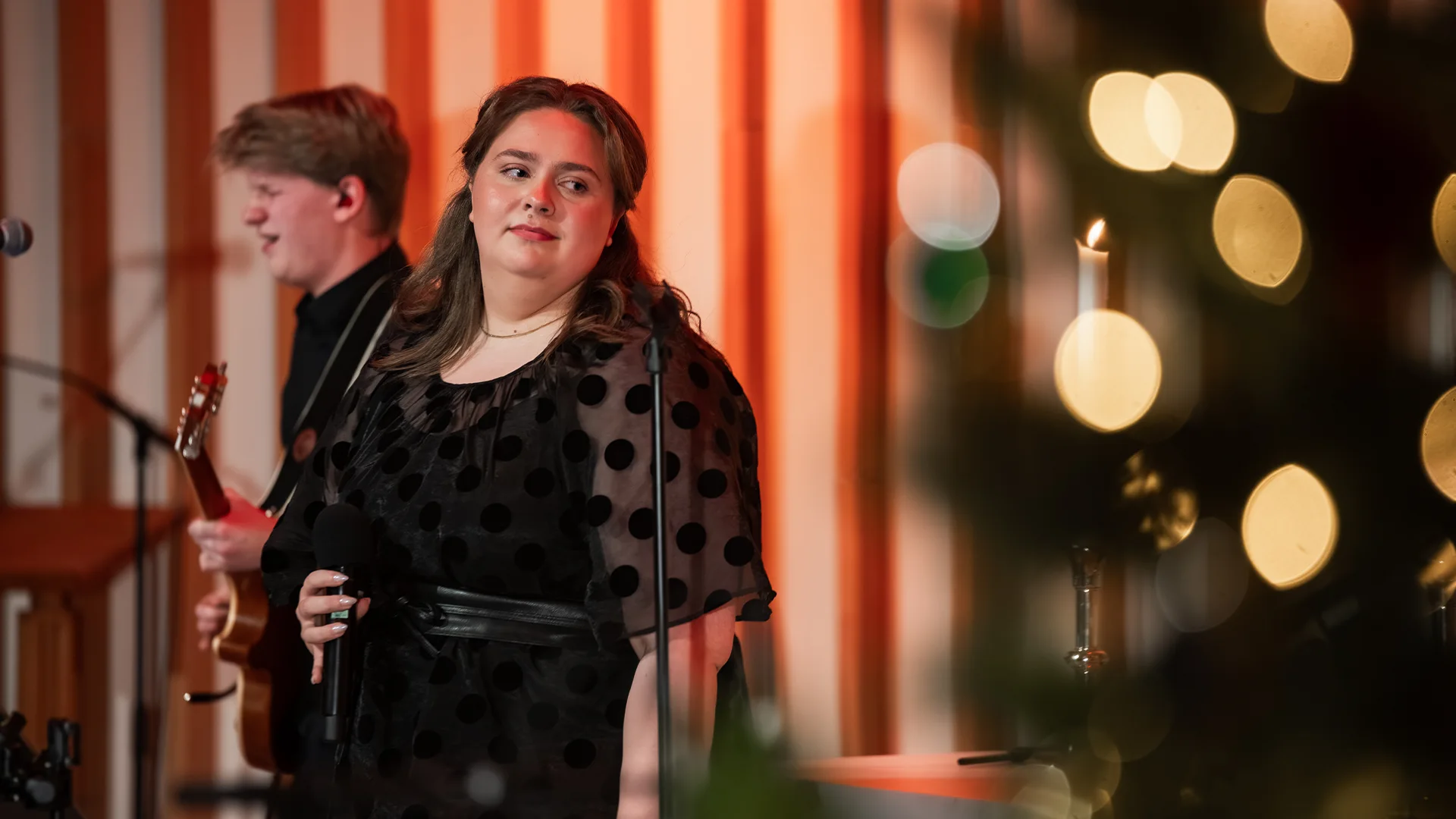 Andrea-Bredesen-Holm stands on stage in christmas setting ready for christmas show.