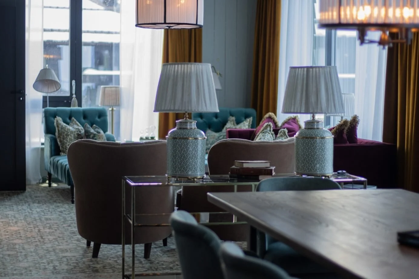 Executive_Suite_Fyri_Resort Elegant lounge with sofas, patterned cushions, table lamps, and floor-to-ceiling windows
